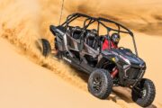 A dune buggy mid-air performing an extreme jump in the desert.