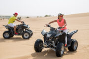 Tourists riding quad bikes on the sand dunes.