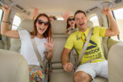 A group of happy tourists inside a 4x4 vehicle, ready for a desert safari.