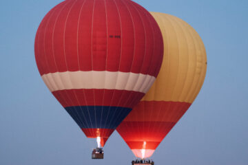 Hot air balloon floating over the Dubai desert at sunrise.