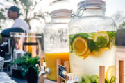 Infused water and fresh orange juice displayed at an outdoor desert breakfast.