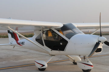 Light Sport Aircraft A6 MEC parked on the runway with an open cockpit.