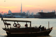 Traditional Abra Boat Sailing at Sunset with Dubai Skyline