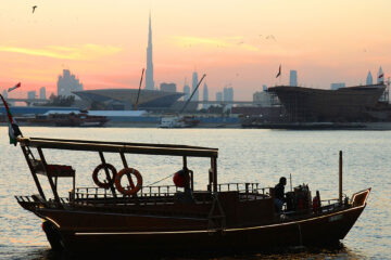 Traditional Abra Boat Sailing at Sunset with Dubai Skyline