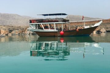 Dhow boat reflecting on calm waters of Musandam