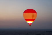 Hot air balloon floating over the Dubai desert at sunrise.