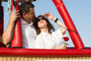 Romantic couple embracing near a hot air balloon burner.