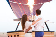 A couple inside a hot air balloon basket, enjoying the ride.