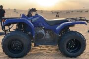 Yamaha Grizzly 350cc quad bike parked on desert sand at sunset.