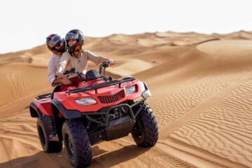 Couple riding a Suzuki King Quad 4x4 on the sand dunes