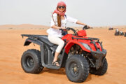 Woman enjoying a quad bike ride on desert dunes