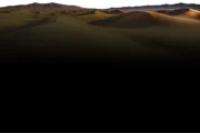 A breathtaking sunset over a vast expanse of desert dunes.