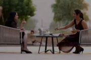 Two women seated at a modern outdoor table, enjoying a meal in a natural setting.