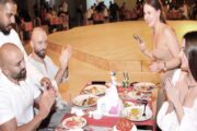 Group celebrating birthday with cake and dinner at desert safari camp