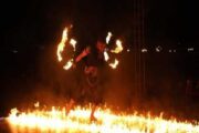 Fire performer walking through flames during a desert safari show