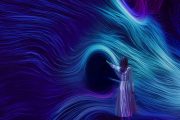 Woman touching swirling digital waves of blue and purple light at TeamLab Phenomena Abu Dhabi