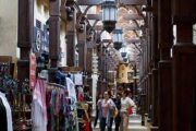 Traditional wooden corridor of Souk Madinat Jumeirah with shops and people exploring