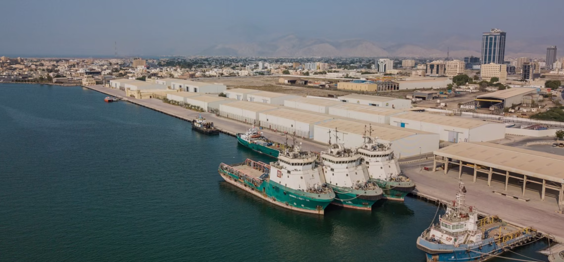 Aerial view of Ras Al Khaimah Port with docked cargo ships and city skyline in the background