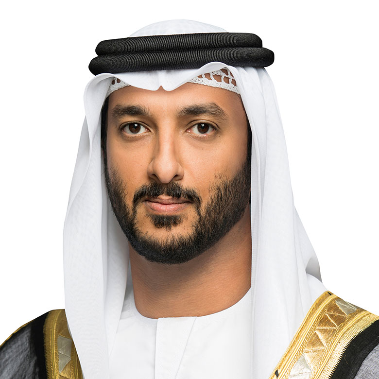 Portrait of an Emirati leader wearing a white kandura, black agal, and ceremonial gold-trimmed bisht, looking directly at the camera.