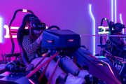 Woman using a VR racing simulator at Pixoul Gaming Abu Dhabi.