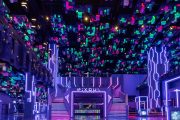 Neon-lit futuristic lobby of Pixoul Gaming Abu Dhabi with pixel-style ceiling.