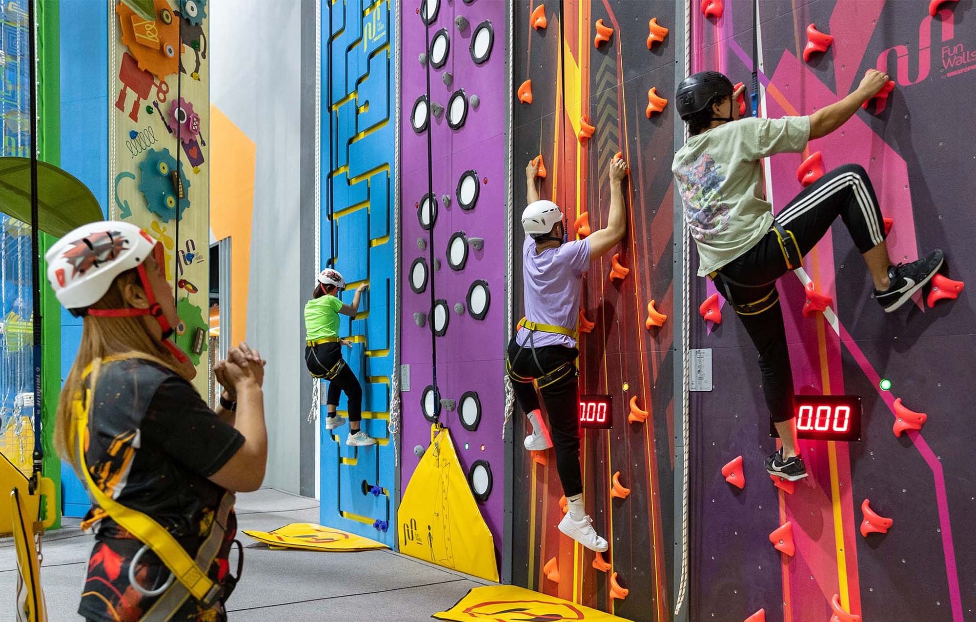 Indoor climbing wall experience at Adrenark Adventure Abu Dhabi with participants in harnesses