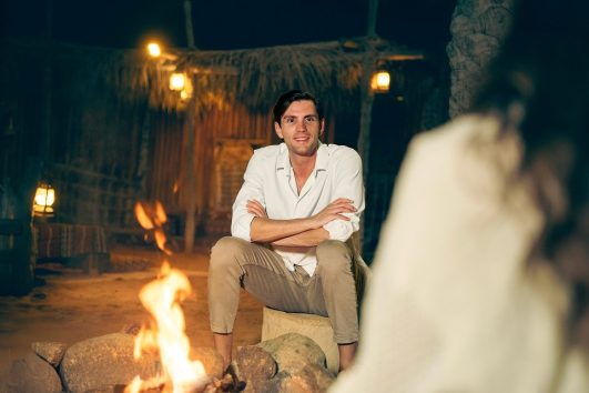 guest relaxing by campfire in desert safari camp