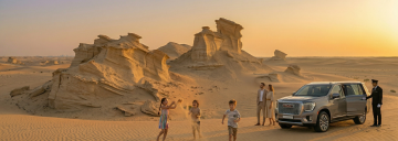 family playing in Al Wathba fossil dunes Abu Dhabi with luxury SUV and chauffeur service at sunset