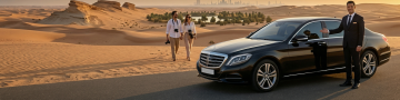 Private chauffeur with luxury sedan in Abu Dhabi desert near Al Wathba Fossil Dunes with travelers exploring scenic dunes
