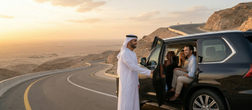chauffeur opening luxury SUV door for couple on mountain road Al Ain UAE