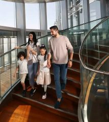 family walking inside Burj Khalifa observation level with glass walls