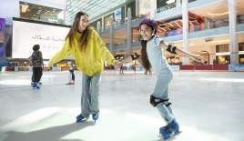 couple enjoying ice skating together indoor rink Dubai