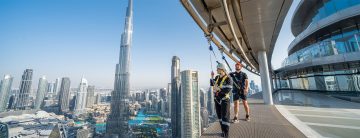people doing edge walk Sky Views Dubai with instructor overlooking Burj Khalifa skyline