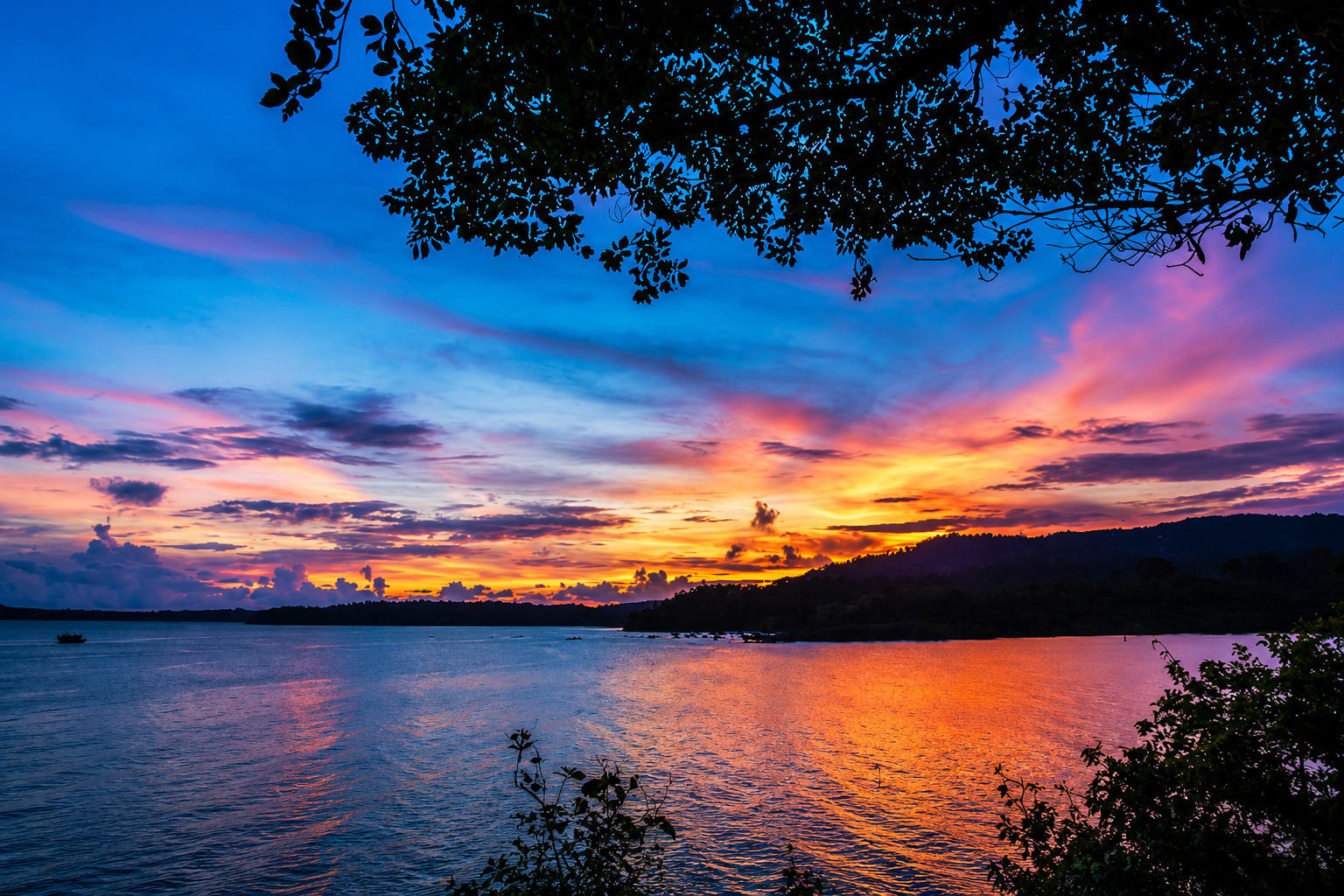 Un tramonto vibrante sul Mar delle Andamane, con nuvole suggestive e acque calme.