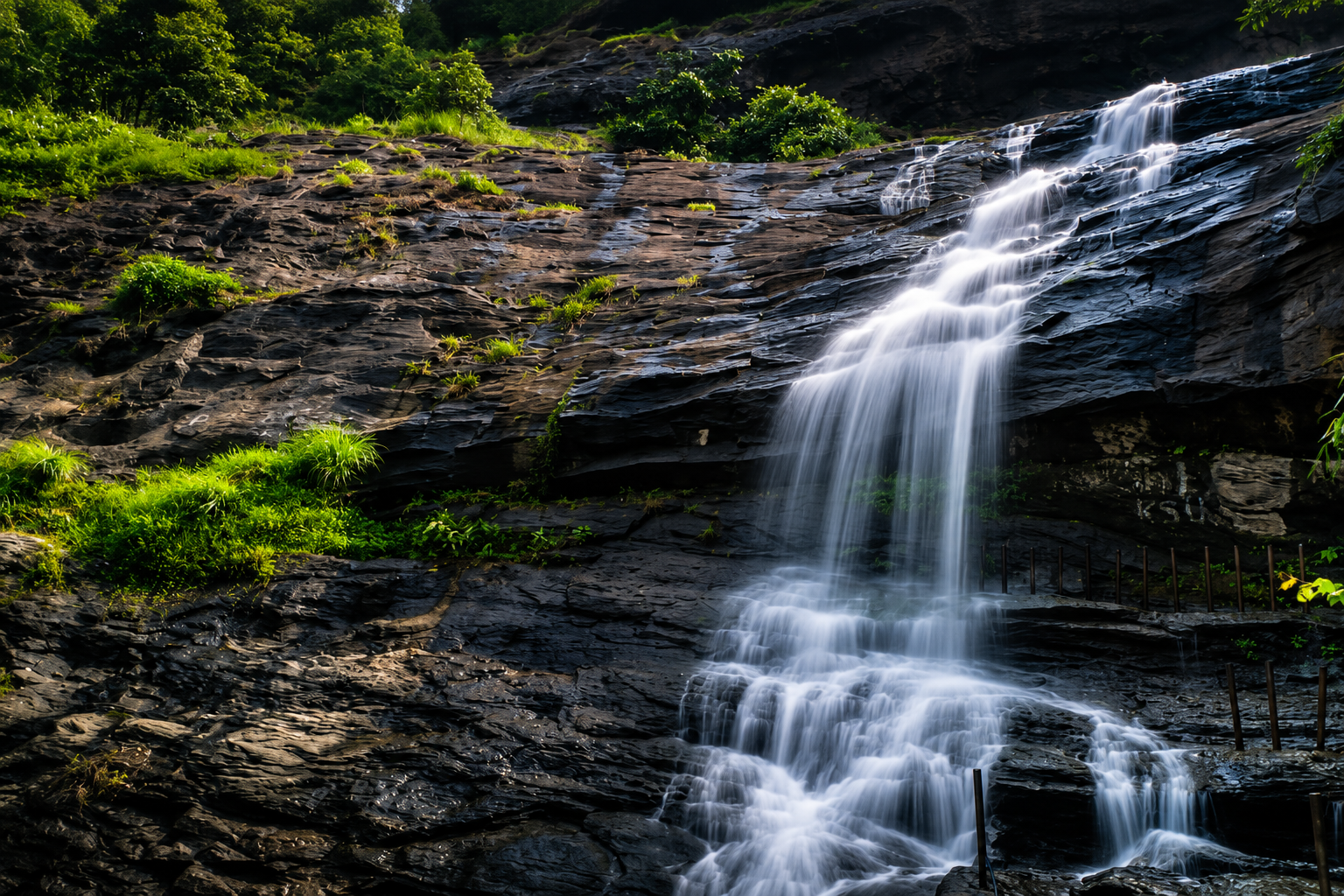 Cheeyappara Waterfalls cascading down rocky cliffs surrounded by lush greenery near Munnar in Kerala.