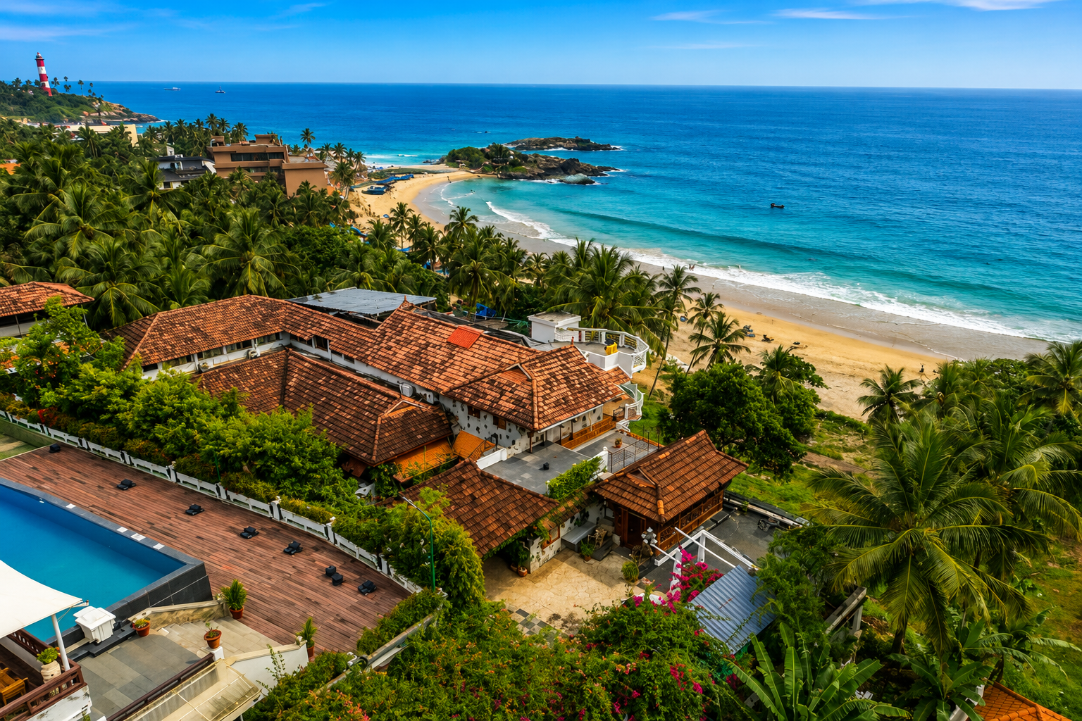 Drone view of Vizhinjam Lighthouse standing on a rocky peninsula overlooking Kovalam Beach and the Arabian Sea in Kerala.