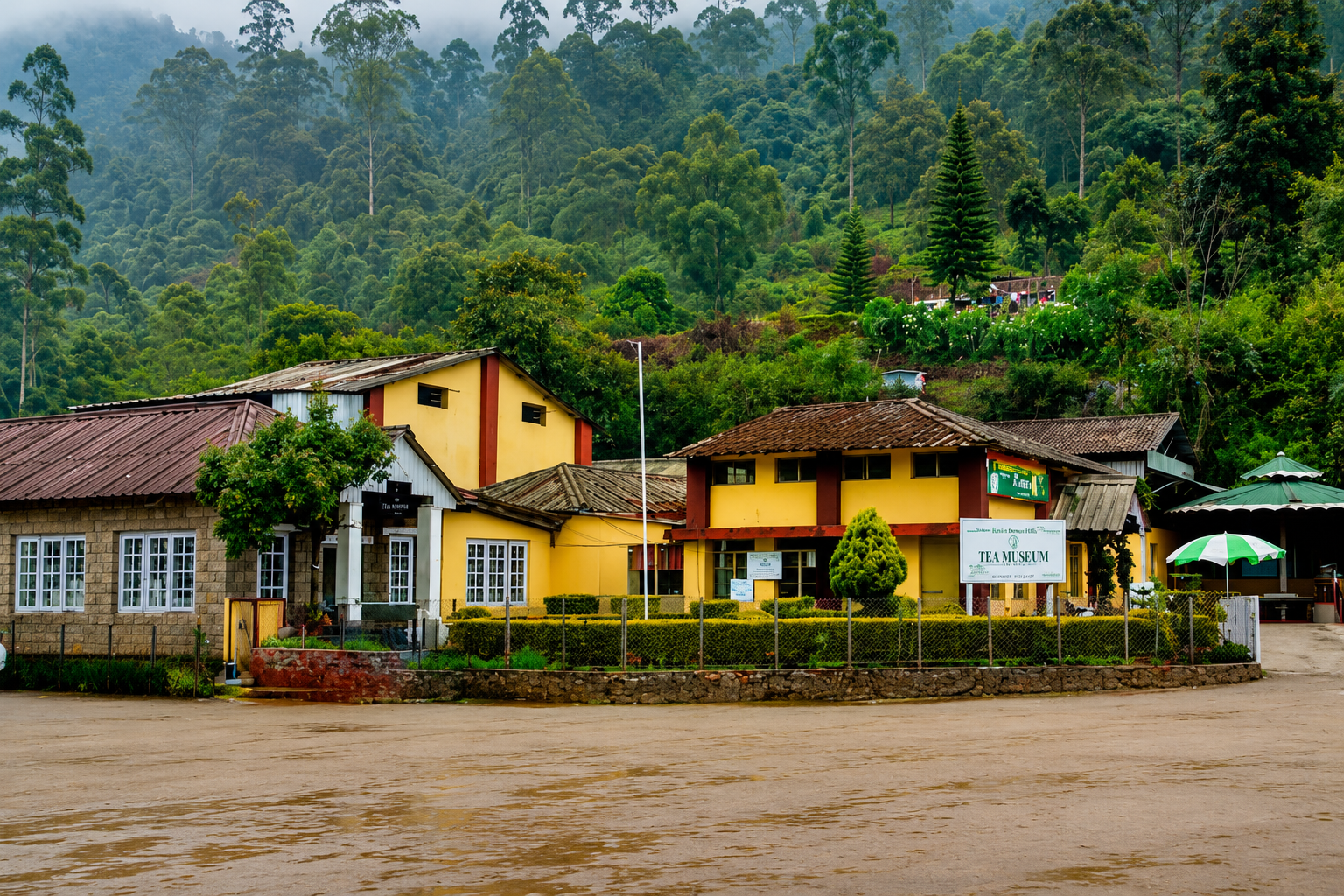 Front view of the Lockhart Tea Museum surrounded by lush green hills and forests in Munnar, Kerala.