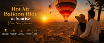 Couple enjoying a sunrise hot air balloon ride above the golden sand dunes of Dubai Desert.