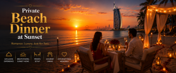 Couple enjoying a private candlelit dinner on a Dubai beach with Burj Al Arab at sunset.