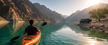 Traveler kayaking on Al Rafisah Dam surrounded by Hajar Mountains in Khor Fakkan UAE